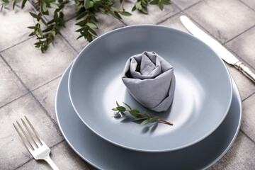 Beautiful table setting with plant branches on grey tile background