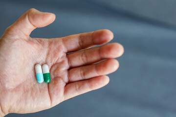 Male hand holding capsules with blur background