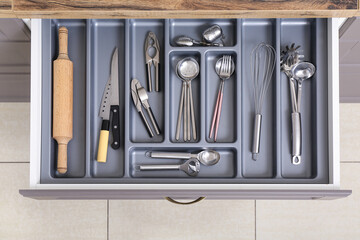 Open kitchen drawer with different silver cutlery