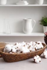 Basket of cotton flowers with kitchen dishes on table