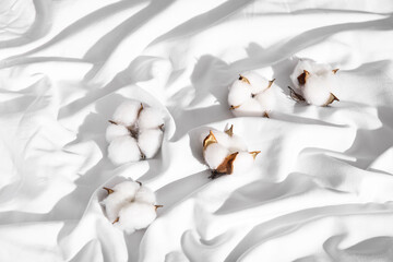 Cotton flowers on white bed sheets