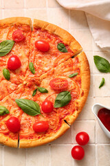 Tasty pizza margarita on beige tile background