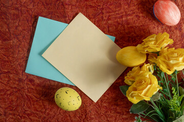 Easter decorations with yellow roses, painted eggs and colored paper.