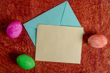Colorful Easter eggs with letter and envelope, on a textured background.
