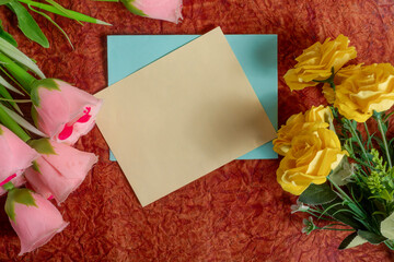 Floral arrangement with blank card on decorative background