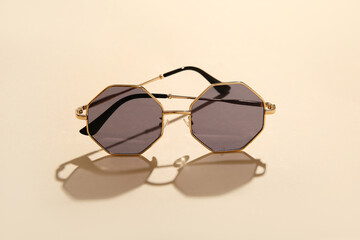 Stylish sunglasses on beige background