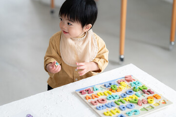 アルファベットパズルをする1歳の男の子