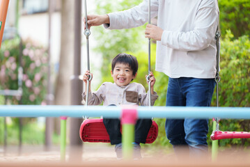 Obraz premium ブランコで遊ぶ5歳の男の子と40代の父親 