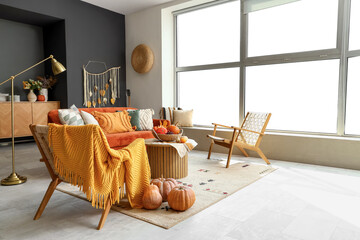 Interior of living room with sofa, armchairs and pumpkins
