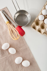 Preparation area for baking with eggs and mixing tools on countertop