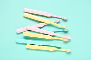 Colorful plastic toothbrushes on color background.