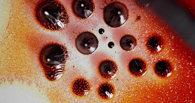 Alcohol ink flowing and blending to create mesmerizing abstract patterns and shapes in vibrant orange and brown hues, perfect for backgrounds and textured designs