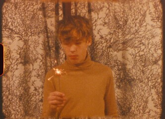 Teenager celebrates their 14th birthday with a sparkler, capturing the moment in a vintage, nostalgic style, evoking a sense of retro charm and youthful joy