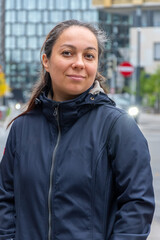 Portrait of a modern woman 40-45 years old in city clothes. Themes of travelling, work or city life.