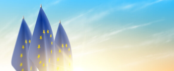 Banner with European Union flags. EU flags isolated on cloudy sky at sunrise. Realistic flags for decoration EU events. Symbol of European Union. Vector illustration.