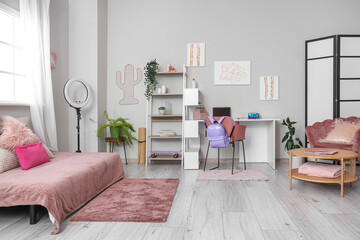 Interior of children's room with bed, table and backpack on chair