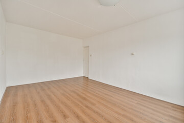 An uncluttered, minimalist interior featuring smooth wooden flooring, white walls, and a simple ceiling light, providing a serene atmosphere.