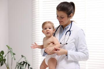 Pediatrician with cute little baby in clinic