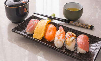 chopsticks, glass and plate with Japanese sushi on the table