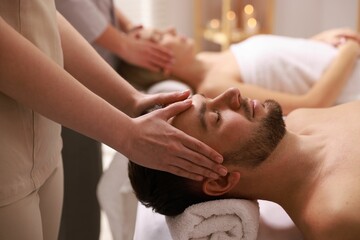 Couple receiving relaxing massage in spa salon, selective focus