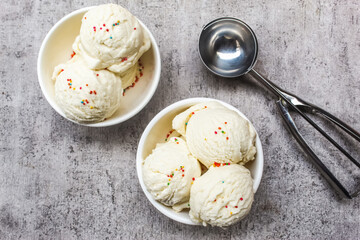 vanilla scoop ice cream in a bowl with colorful sprinkles