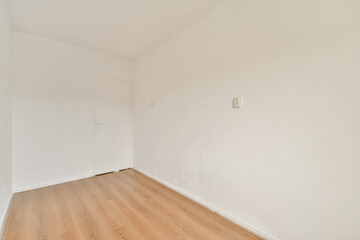 A clean and minimalist interior space featuring plain white walls and a wooden floor, exuding simplicity and openness. Ideal for modern decor concepts.