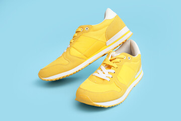 Stylish male yellow sneakers on blue background