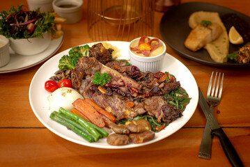 Grilled T-Bone steak served with vegetables and mushroom sauce. Landscape angle perfect for menu and media. Perfect for advertising and commercial purpose.