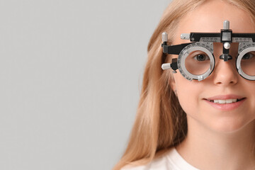Teenage girl in trial frame on light background, closeup. Children's Eye Health and Safety...