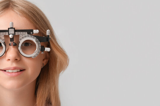 Teenage girl in trial frame on light background, closeup. Children's Eye Health and Safety Awareness Month - Powered by Adobe