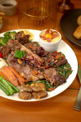 Grilled T-Bone steak served with vegetables and mushroom sauce. Perfect for advertising and commercial purpose. Close up angle perfect for menu