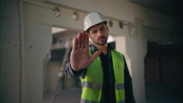 Serious dissatisfied Caucasian man showing hand gesture stop deny no build male guy builder reject not forbidden keep distance refusal sign worker repairman architect construction engineer contractor