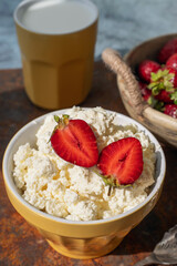 Fresh strawberry curd cheese, served in a yellow bowl along with a bowl of fresh strawberries. Healthy Breakfast.