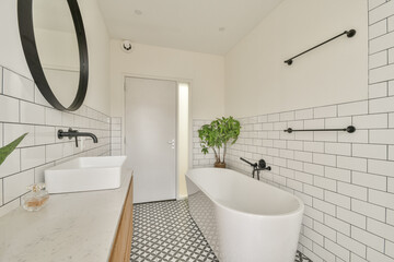 A stylish modern bathroom featuring a freestanding tub, elegant fixtures, and minimalistic decor that emphasizes clean lines and a serene atmosphere.