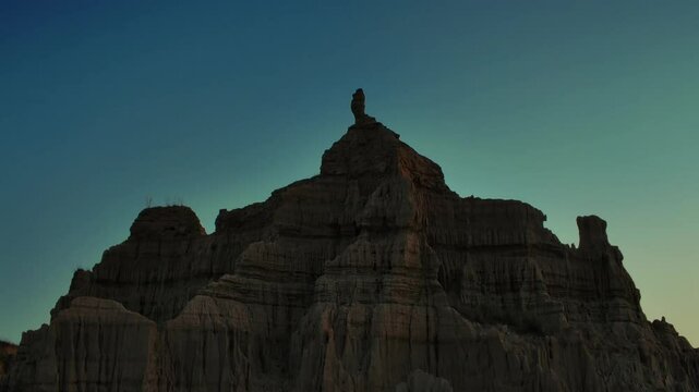 Sandstone cliff standing under clear sky at sunrise in Chakwal Canyons of Pakistan