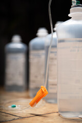 symbolic illness mood chancer. hospital equipment for healthcare. medicine bottle and syringe. infusion bags standing in a row with dark background. 