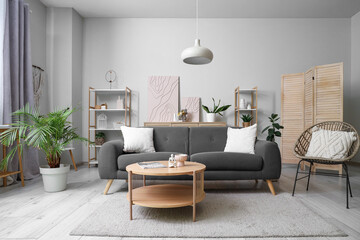 Interior of living room with sofa, armchair and shelf units