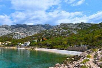 Beach at Lukovo village at the coast of the Adriatic sea with rocky slopes of Velebit mountains...