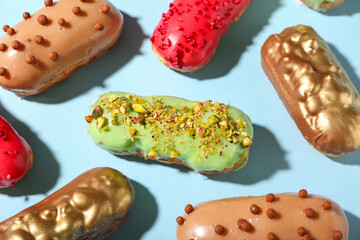 Composition with various glazed eclairs on color background