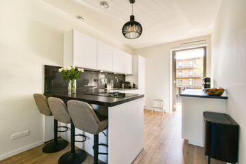 A stylish modern kitchen featuring sleek cabinetry, a central island, and natural light enhancing the minimalist aesthetic. Ideal for contemporary living.
