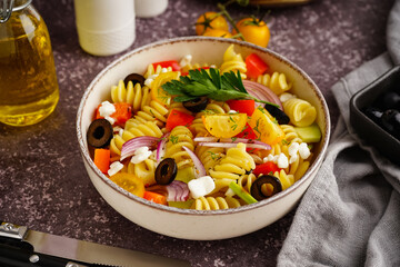 Plate with traditional pasta salad on table