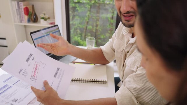Couple facing overdue bills and financial pressure at home, stressed by inflation and economy recession