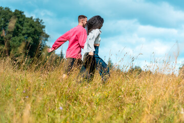 Gen Z couple holding hands and enjoying nature on a sunny day