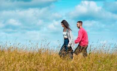 Young couple holding hands and enjoying nature under the blue sky
