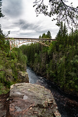 This breathtaking high railway bridge crosses the river &Auml;m&aring;n, nestled within the lush, green landscapes of Deep Canyon Storstupet in Sweden.

