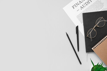 Naklejka premium Composition with stationery, eyeglasses and financial documents on grey background