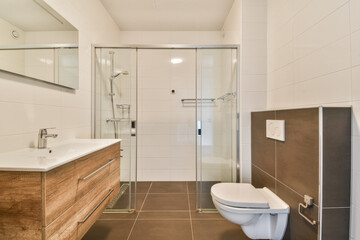 A stylish and contemporary bathroom featuring a glass shower, wooden vanity, and sleek fixtures, showcasing functionality and elegance.