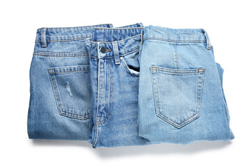 Set of stylish blue jeans on white background