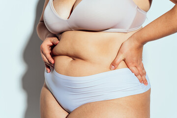 Plus size woman posing in studio in lingerie
