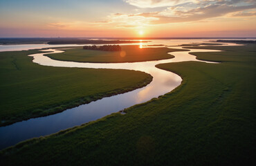 River delta at sunset with winding waterways and lush marshlands.